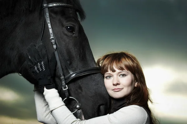 Krásná mladá žena s černým koněm — Stock fotografie