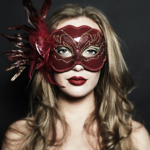 Gyönyörű fiatal nő, egy piros titokzatos maszk — Stock Fotó