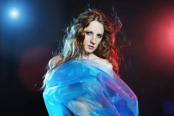 Portrét mladé tančící ženy proti barevné záblesky — Stock fotografie