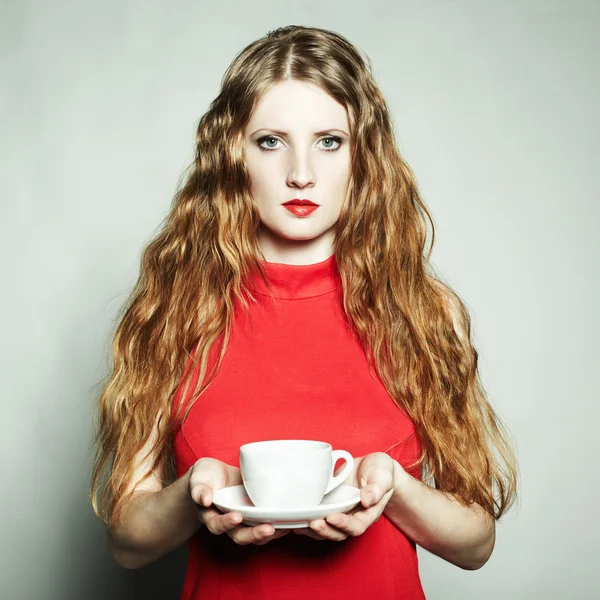 Portret vrouw in een rode jurk met een kopje koffie — Stockfoto