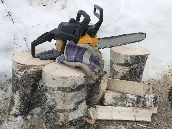 Firewood and a chainsaw — Stock Photo, Image