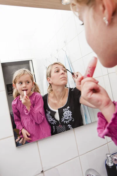 Mother and daughter put on make-up — Stock Photo, Image