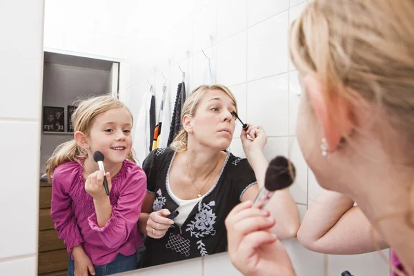 Moeder en dochter zetten make-up — Stockfoto
