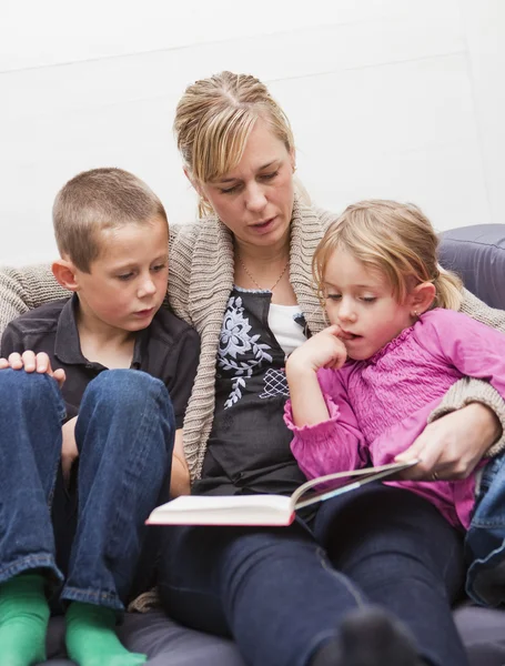 Mother reading a book to her children — Stock Photo, Image