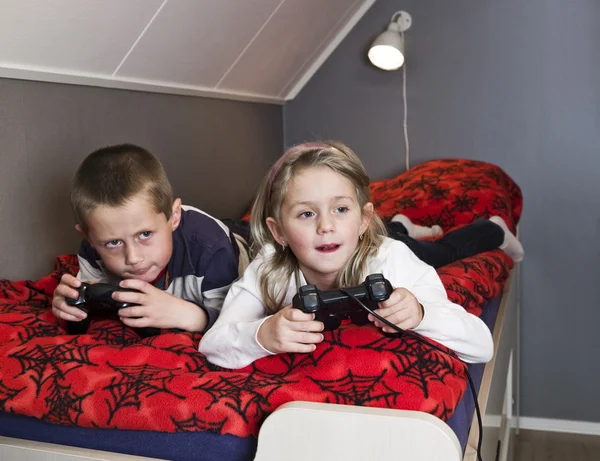 Frères et sœurs jouant à des jeux vidéo — Photo