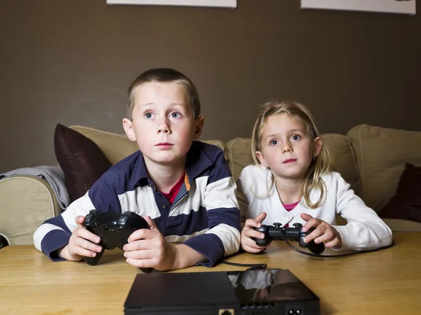 Siblings playing video games — Stock Photo, Image