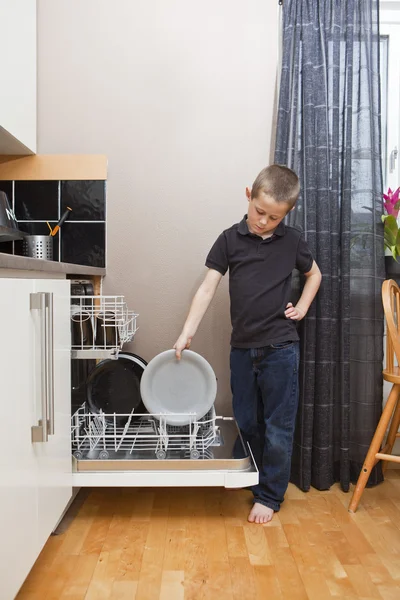 เด็กหนุ่มโดยเครื่องล้างจาน — ภาพถ่ายสต็อก