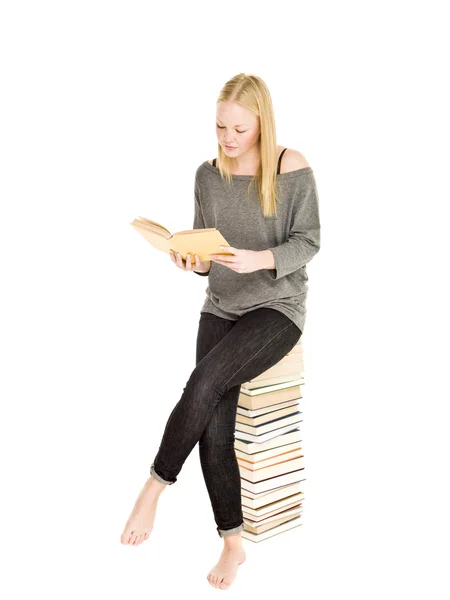 Mladá dívka na hromadě knih — Stock fotografie