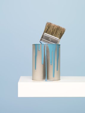 Paintcan and brush on blue background clipart