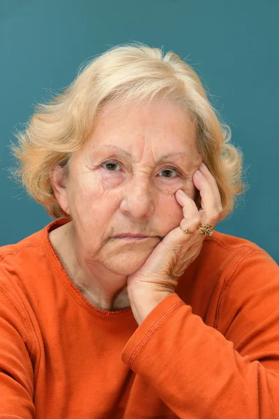 Senior vrouw gaan zitten mokken — Stockfoto