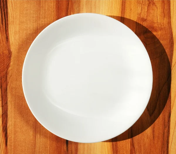 Plato de cena blanco sobre mesa de madera — Foto de Stock