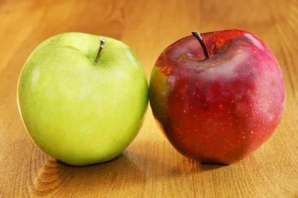 Červená a zelená jablka na stole — Stock fotografie