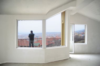 Young man looking from his new home balcony clipart