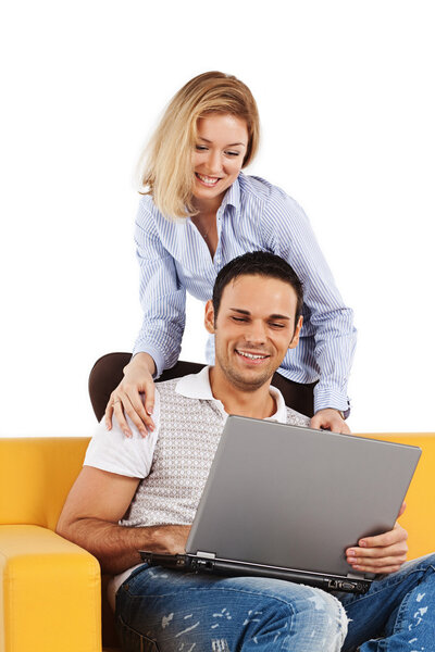 Happy young man and woman sitting together and looking at computer screen