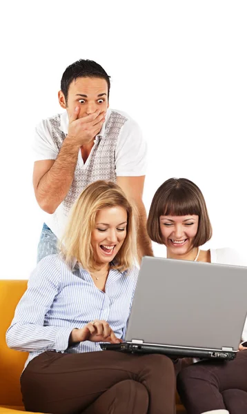 年轻男子震惊所看到的两个快乐女孩在计算机上做什么 — 图库照片
