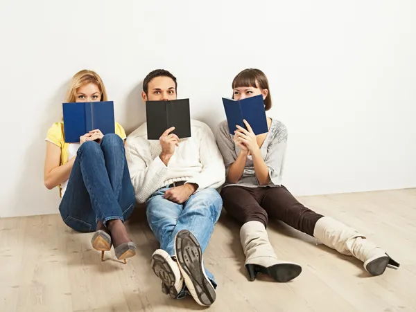 Trois amis amusés avec des livres — Photo