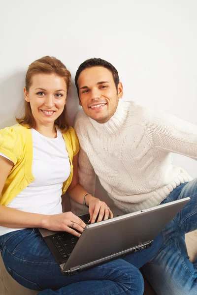 そのラップの上にラップトップ コンピューターで床に座って幸せな若いカップル — ストック写真