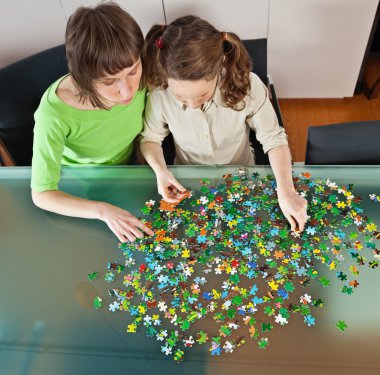 Girl and mom doing puzzle clipart