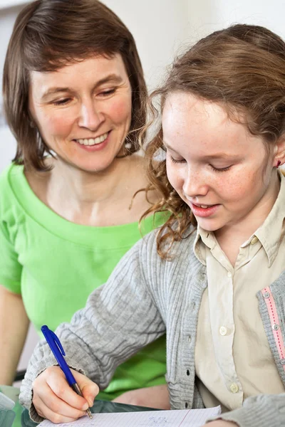 Ragazza che fa i compiti con sua madre — Foto Stock