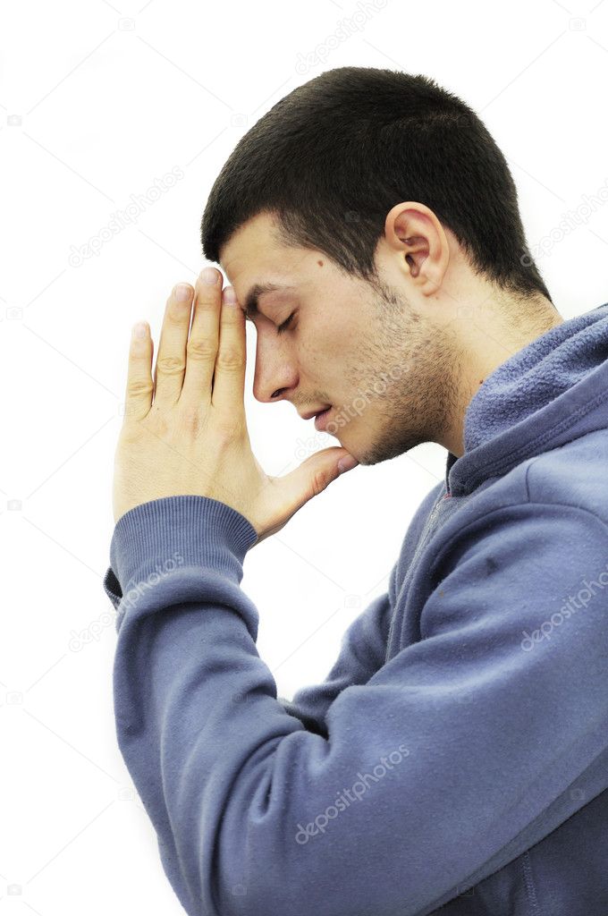 Young man praying, isolated on white