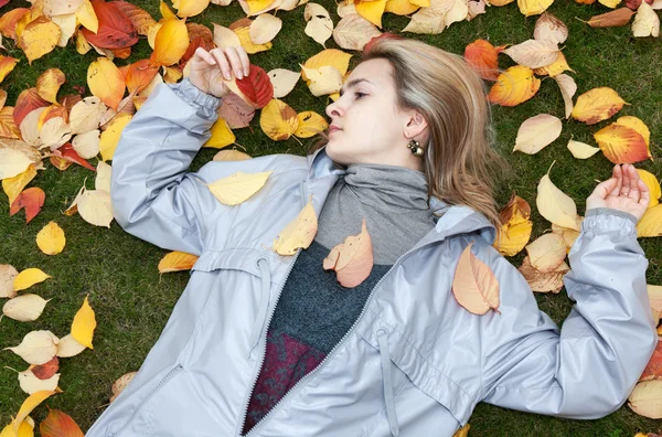Piękna dziewczyna opiera się na jesień arkusz — Zdjęcie stockowe