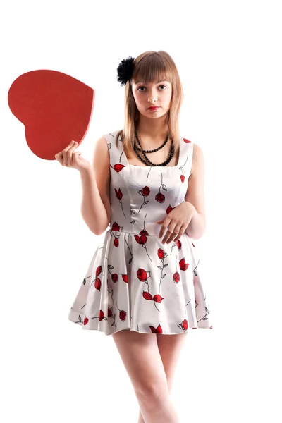 Красивая девушка в платье с красным цветом и сердцем в руке — стоковое фото