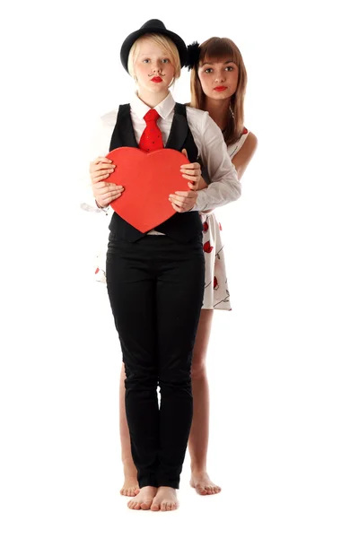 Две девушки с красным картонным сердцем — стоковое фото
