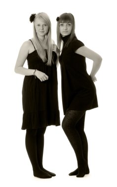 İki kız ile beyaz bir arka plan (siyah ve beyaz siyah elbiseler)