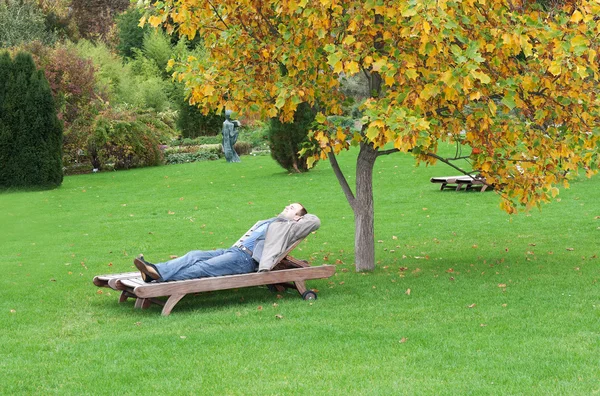A man, lying on a lounger — Stock Photo, Image