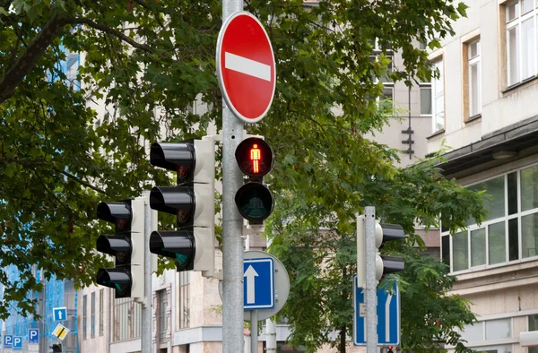 記号上の旅行と交通信号灯の禁止前の緑の木 — ストック写真