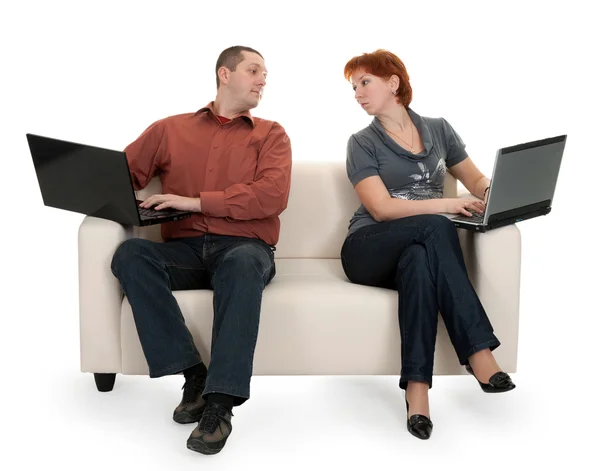 stock image Husband and wife sitting on the couch with laptops