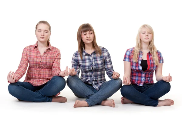 Três meninas sentadas na postura de lótus — Fotografia de Stock