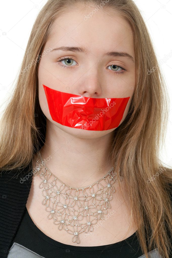 Beautiful girl with her mouth sealed with red tape