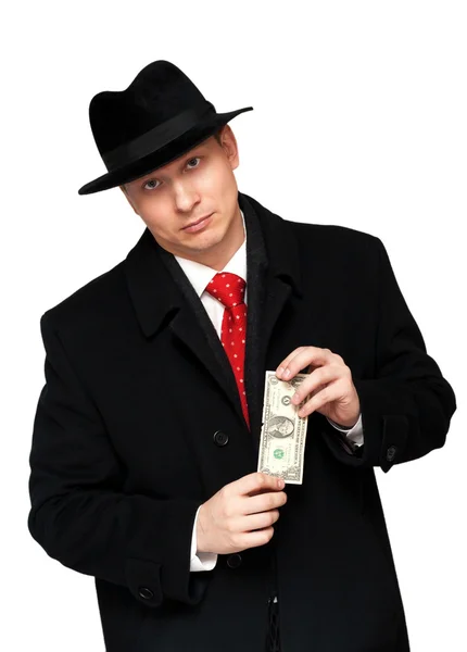 stock image Man in an overcoat and hat, with the dollar in the hands of