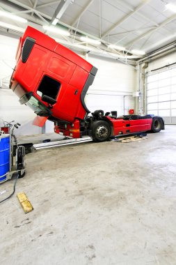 Open red truck in big service garage clipart