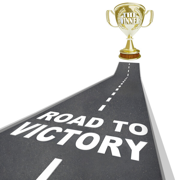 The words Road to Victory in white letters on a street leading to a golden trophy