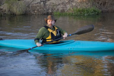 Adult paddler in blue kayak clipart