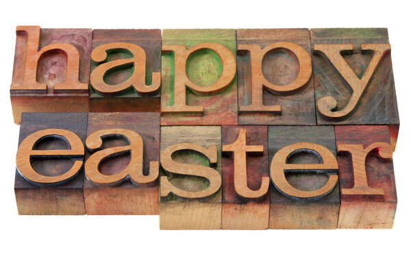 Happy easter- words in vintage wooden letterpress printing blocks, stained by color inks, isolated on white