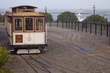 San Francisco cable car at Hyde Street turntable (Fisherman's Wharf) with foggy Aquatic Park in background clipart