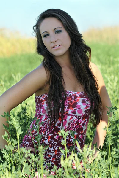 Mladá dospívající dívka venkovní uprostřed zelené rostliny v šatech — Stock fotografie