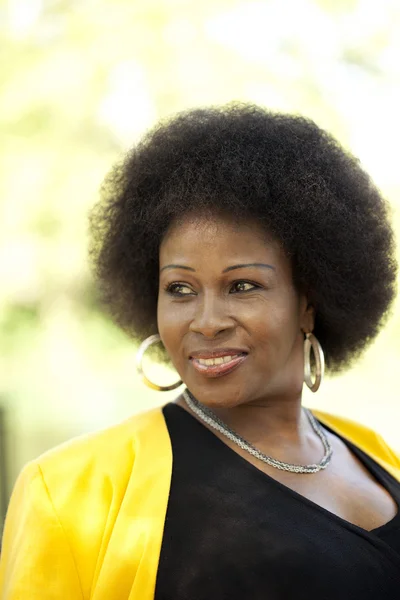 Medelålders svart kvinna utomhus porträtt gul jacka — Stockfoto