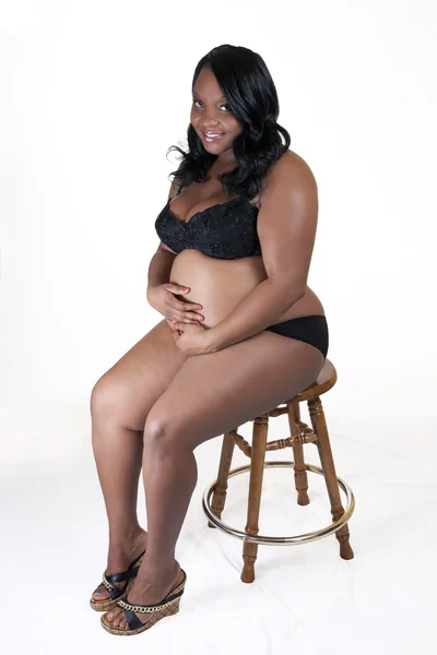 Jeune femme enceinte noire tenant de la lingerie ventre — Photo