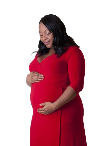 Kırmızı elbise duran genç Afro-Amerikan hamile kadın