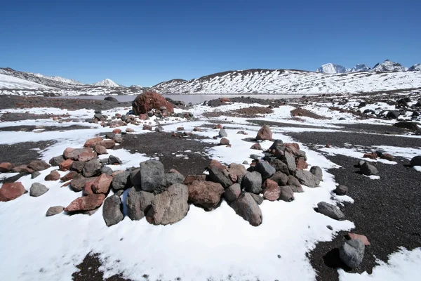 Círculo de pedra e neve contra lago de montanha no Cáucaso — Fotografia de Stock