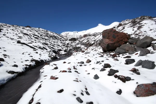 Rivière glaciaire entre pierres et montagnes de neige — Photo
