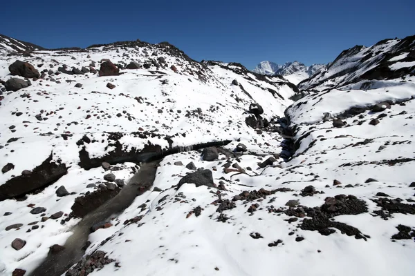Fiume ghiacciaio tra sassi e neve Montagne del Caucaso — Foto Stock