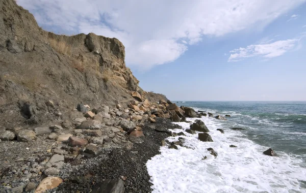 海洋海岸与鹅卵石和岩石的天空 — 图库照片