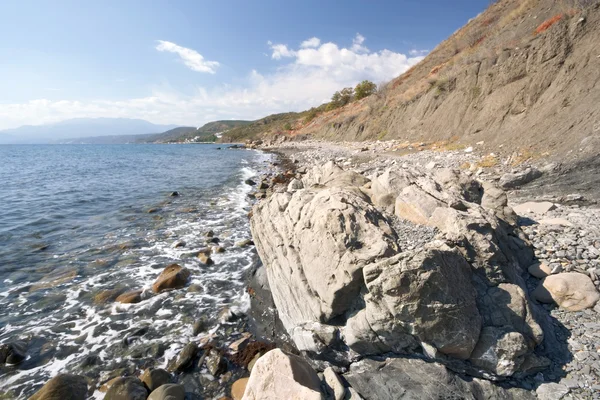 Sea coastline with foam, stones, pebbles and rocks — Stock Photo, Image