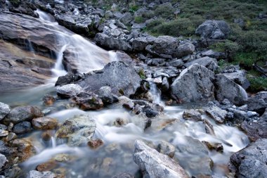 Water stream flowing among stones and rocks. clipart