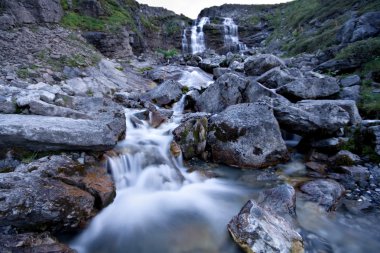 Water stream of mountain river flowing from rocks. clipart